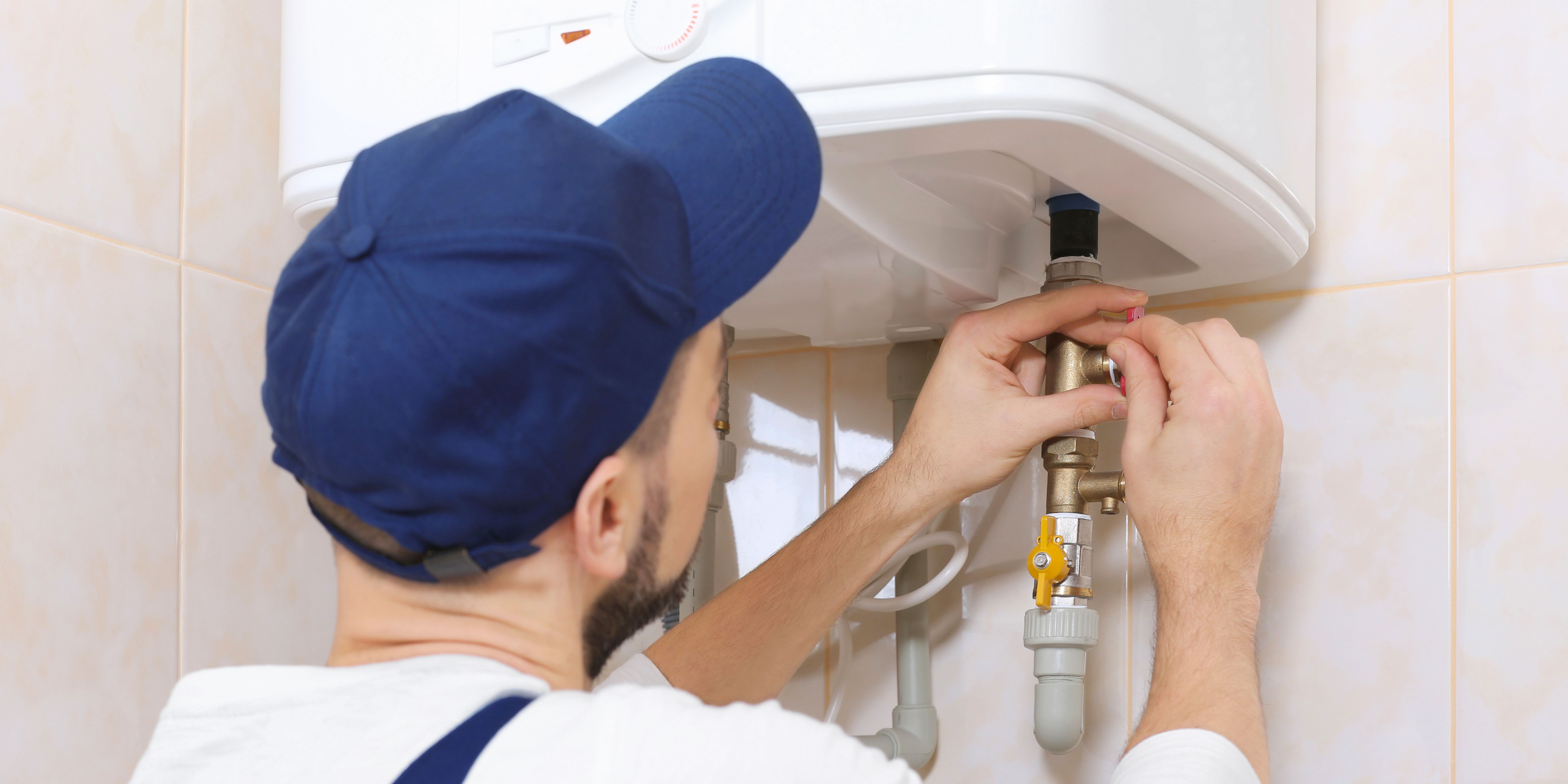 A COmplete Plumber installing a tankless water heater.