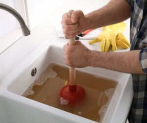 Kitchen sink filled with brown water for Will OxiClean Unclog a Drain that is Clogged.