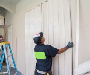 A man is prepping a home for a hurricane or major storm.